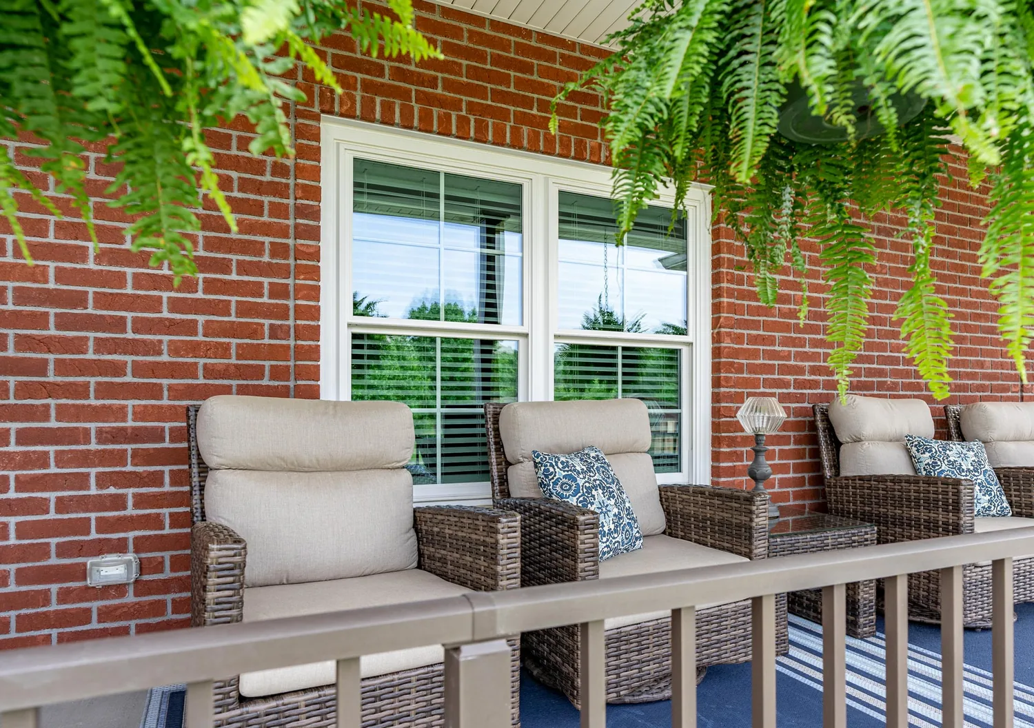 ProVia Endure white twin double-hung windows with optional cottage grids on a brick porch